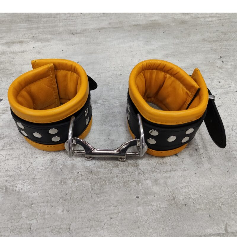 Bőr párnázott kézbilincs sárga/fekete.